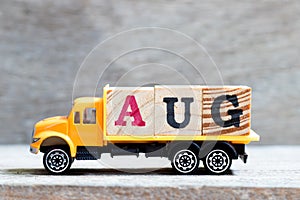 Truck hold block in word Aug on wood background Concept for month August