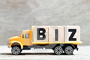 Truck hold block in word biz abbreviation of business on wood background