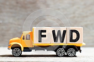 Truck hold block in word FWD Abbreviation of forward on wood background