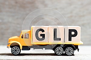 Truck hold block in word GLP Abbreviation of Good laboratory practice on wood background