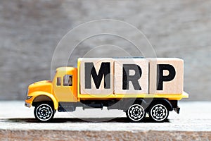 Truck hold block in word MRP Abbreviation of Material requirements planning on wood background