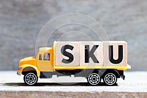 Truck hold block in word SKU abbreviation of stock keeping unit on wood background