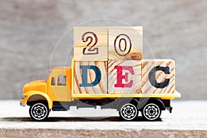 Truck hold letter block in word 20dec on wood background Concept for date 20 month December