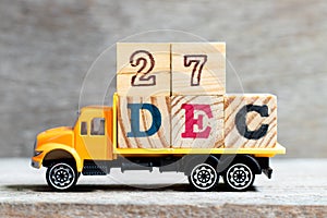 Truck hold letter block in word 27dec on wood background Concept for date 27 month December