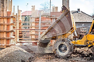 Truck loader excavating gravel and construction aggregates. Construction site with dumper truck and materials