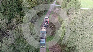 Truck loading chipped wood from forest machine