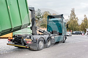 Truck loading container with waste green on recycling center