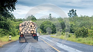 Truck with logs on small highway