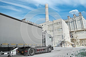 A truck with a long body is waiting for loading at a chalk factory.