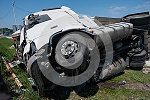 The truck is lying on its side in a car accident on the highway