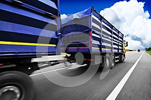 Truck in motion with a container driving on the countryside road