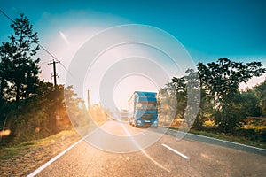 Truck In Motion On Country Road In Sunset Sun Sunshine Natural Sunlight. Tractor Unit, Prime Mover, Traction Unit On