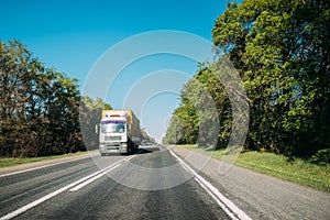 Truck On Country Road. Tractor Unit, Prime Mover, Traction Unit In Motion On Countryside Road In Europe. Business