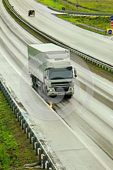 Truck moves on wet highway outside city after rain