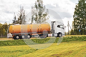 Truck with orange tanker on a road