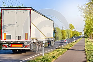 Truck overtakes a small car .