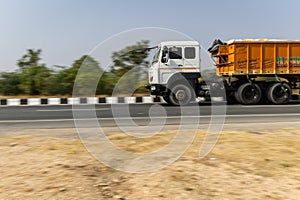 truck passing at national highway with blurred background at day from flat angle