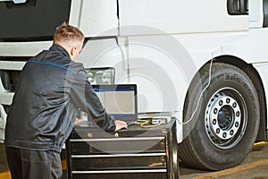 Truck repair service. Mechanic makes computer diagnostic of the semitruck