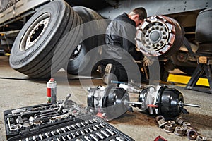 Truck repair service. Mechanic works with brakes in truck workshop