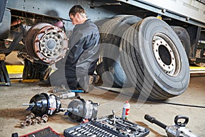 Truck repair service. Mechanic works with brakes in truck workshop