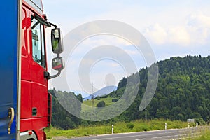 truck rides on the highway through summer forest, meadows and fi