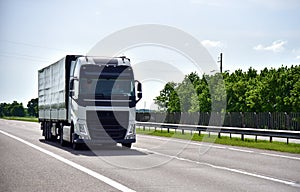 Truck with Semi-trailer driving along highway. Goods Delivery by roads. Services and Transport logistics. Object in motion, soft