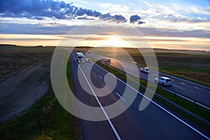 Truck with Semi-trailer driving along highway on the sunset background. Goods Delivery by roads. Services and Transport logistics