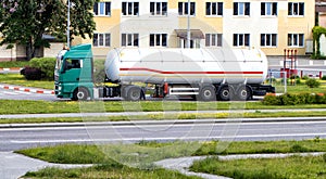 A truck with a semi-trailer tank for the transport of gasoline and diesel drains fuel at a gas station. Dangerous goods