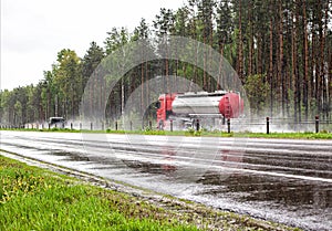 A truck with a semi-trailer tanker transports a dangerous cargo of fuel on a motorway slippery in the rain, industry