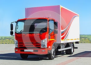 Truck with semitrailer moves along a country road. Front view.