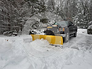 Truck snow plow clearing a parking lot after storm photo