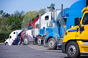 Truck stop with semi trucks various models standing in row