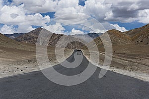 Truck on a straight road in mountain terrain photo