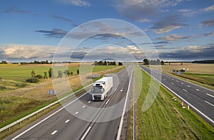 Truck in summer day on empty highway