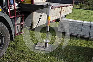 Truck support stand for unloading with a crane