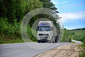 Truck with tipper semi trailer transported sand from the quarry on driving along highway