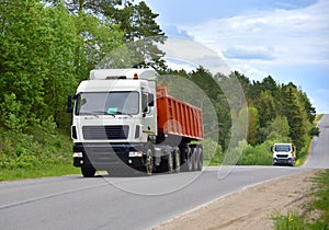 Truck with tipper semi trailer transported sand from the quarry on driving along highway. Modern Dump Semi-Trailer Rear Tipper