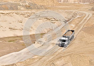 Truck with tipper semi trailer transported sand from the quarry. Dump truck working in open pit mine. Sand and gravel is excavated