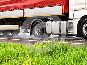 Truck tires in wet weather on wet asphalt. Wet weather road safety concept. Braking distance and aquaplaning