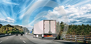 Truck Or Traction Unit In Motion On Road, Freeway. Asphalt Motorway Highway Against Background Of Forest Landscape