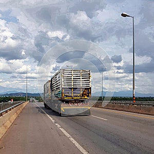 Truck and trailer moving on road against sky