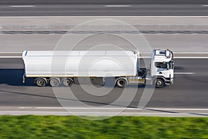 Truck with trailer tank rushes along the highway road.