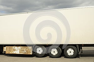 Truck trailer is white. Body of large truck