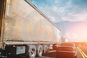 Truck transportation and cars on road or highway at sunset, logistic cargo shipping concept