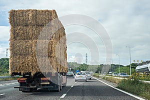 Truck transporting hay bales on a highway