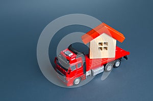 Truck transporting a house. Delivery services to another house. A moving company. Transportation of real estate. Resettlement photo