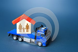 The truck transports the house with the family. Home moving transport company. Relocation for work. Mobility and flexibility of