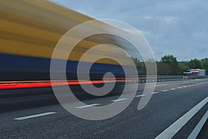 A truck traveling at high speed on the highway. Motion blur on the highway. Motorway light streams. Concept of