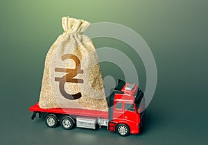 Truck with a ukrainian hryvnia money bag. Reparations. Financial and humanitarian aid. Loan or deposit. Compensation. High super