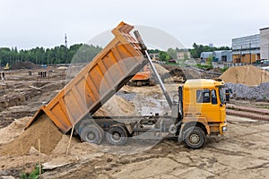 Truck unloads sand on the construction site